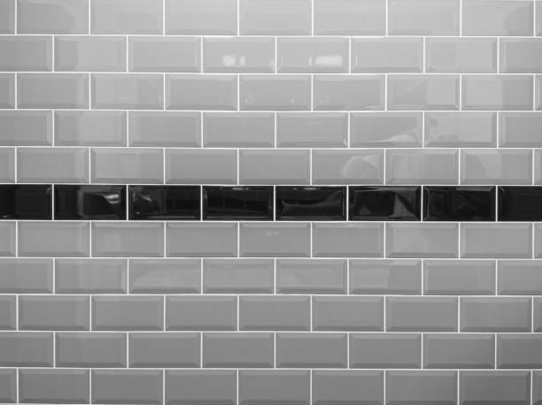 istock Wall lined with gray glossy ceramic tiles with dark line in the center. Decorative wall texture, background. The design of stylish interior. 1331042833