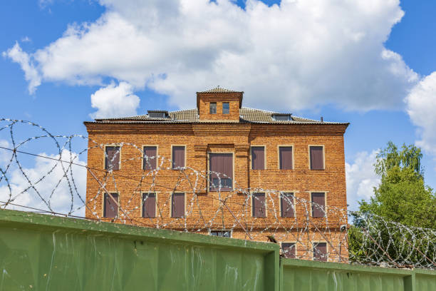 istock Prison building, stone fence and barbed wire 1331046454