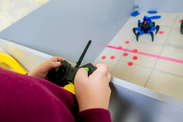 istock The child controls the robot 1331046472