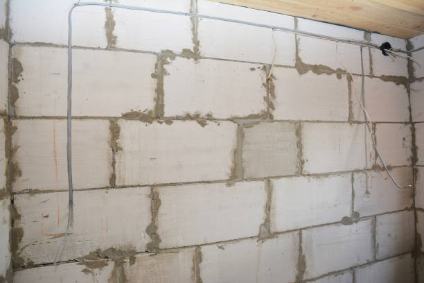 istock Electrical wiring in a new house construction: Electrical box and power cables installation in the wall built from concrete blocks. 1331046544