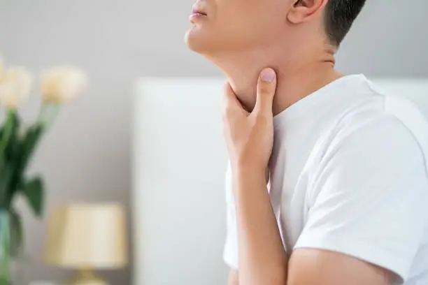 Sore throat, men with pain in neck in home interior, health problems concept