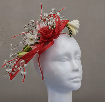 ladies floral fascinator in red and white on a grey coloured plain background