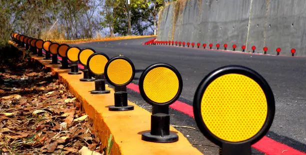 Road reflector beside a curved road,Traffic reflector,Road reflector