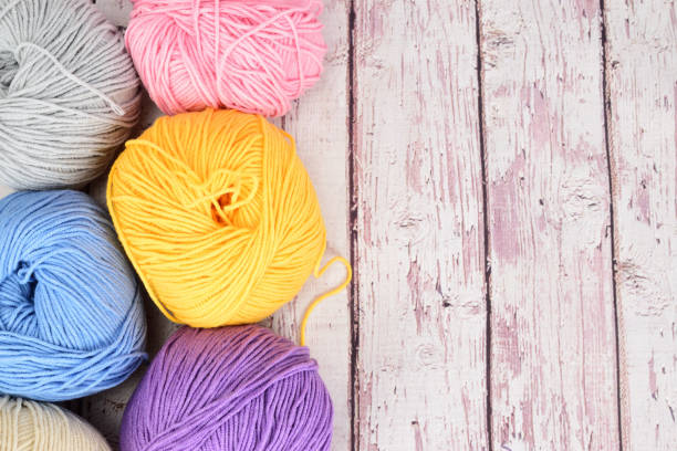 istock Multi-colored crochet wool laid out in several rows on a light wooden surface. 1331058509
