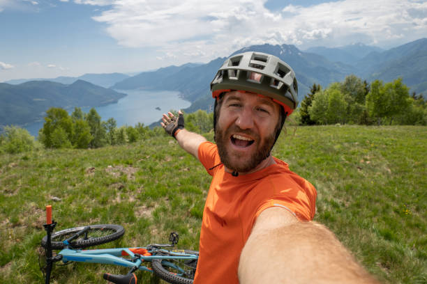 istock Young man mountain biker takes selfie on mountain top 1331059433