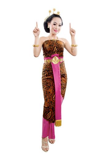 Asian woman with Java traditional dance costume showing something isolated over white background