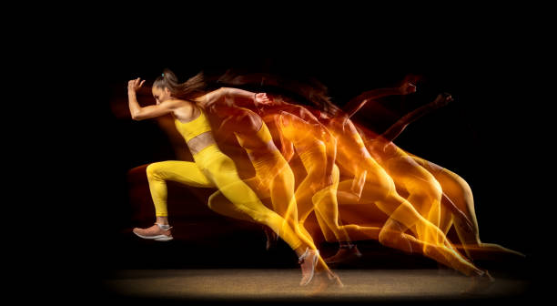 Stroboscopic effect. Young woman, female professional track athlete running isolated over black studio background in mixed neon lights. Concept of sport, healthy lifestyle, motion. Copy space for ad.