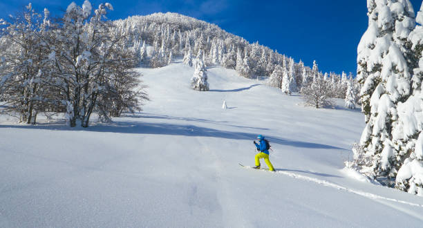 istock AERIAL: Man hikes in the pristine white countryside to splitboard off piste. 1331064600