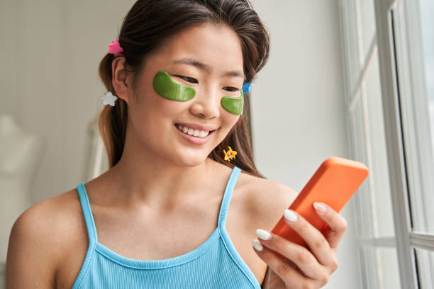 istock Woman wearing hydrogel eye patches using modern smartphone at home 1331064654