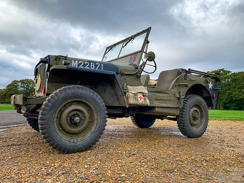 Southampton, UK - 3rd November 2019: Low level view of a British military World War 2 Jeep with Red Cross medical bag and Army camoflage finish. Parked in Southampton Common, England.