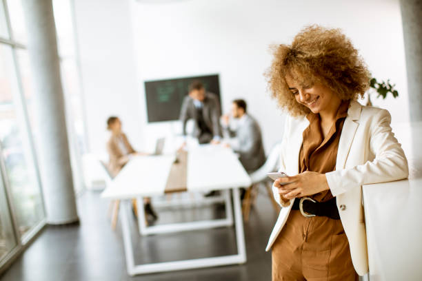 istock Smiling businesswoman using mobile phone in modern office 1331065883