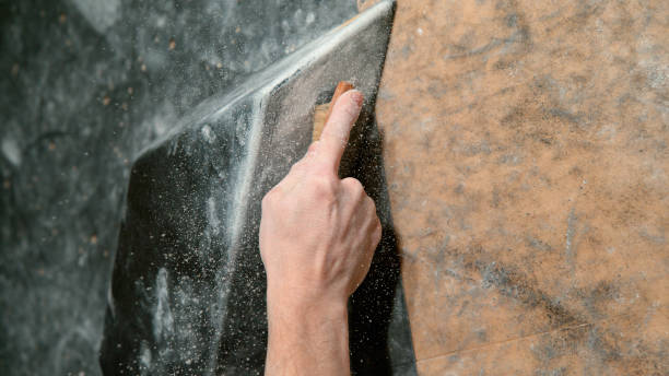istock CLOSE UP: Climber uses a brush to scrub chalk powder off a black volume hold. 1331072300