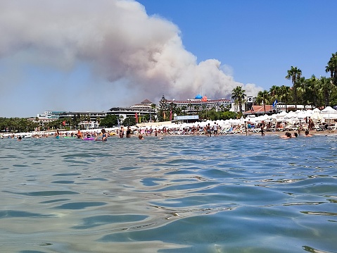July 28, 2021 side. Severe fire in Side, view from the beach with tourists. Strong winds help spread the fire.