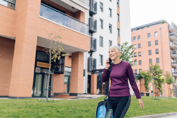 istock Mature woman talking on the phone while going to workout 1331073723