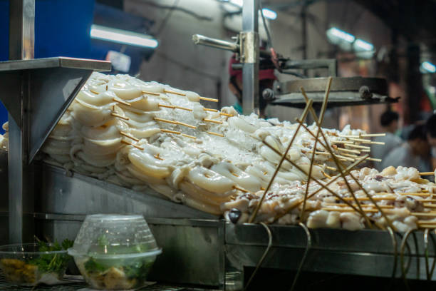 Food grilled skewers grilled squid, The most popular out of the grill.are popular with many people. They are sold in general street shops in Thailand. Squid skewers, fresh squid, Coleoidea, Mollusca, Bather la comida brochetas a la parrilla calamares a la parrilla, el más popular fuera de la parrilla.son populares entre muchas personas. se venden en tiendas callejeras generales en tailandia. brochetas de calamar, calamares frescos, coleoidea, moluscos, bañi