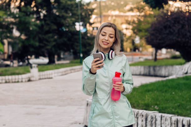 istock Beautiful girl using smartphone after exercising 1331073943