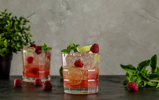 cóctel de vodka de lima frambuesa con menta y hielo. bebida alcohólica refrescante. - raspberry soda fotografías e imágenes de stock