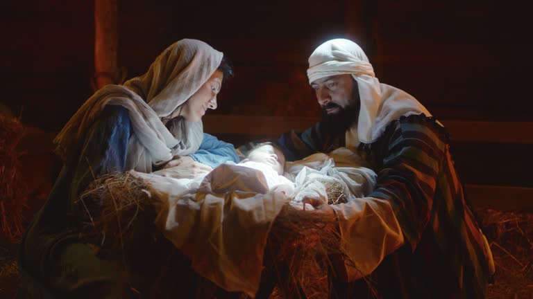 Mary and Joseph caressing baby Jesus in illuminated manger