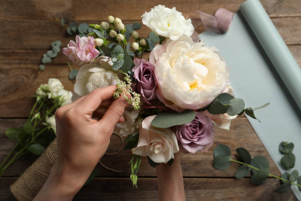 istock Florist creating beautiful bouquet at table, top view 1331075702