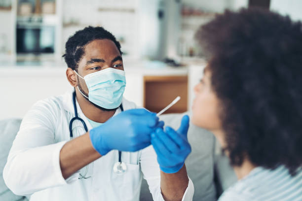 Doctor testing a woman for covid-19 virus stock photo