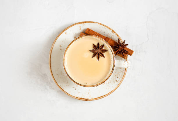 Masala chai tea. Indian hot drink with spices and milk. Latte on a white concrete background. Top view, flat lay. Masala chai tea. Indian hot drink with spices and milk. Latte on a white concrete background. View from above. chai stock pictures, royalty-free photos & images