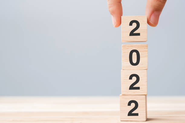 istock hand holding wooden cube block with 2022 text on table background. Resolution, plan, review, goal, start and New Year holiday concepts 1331076695