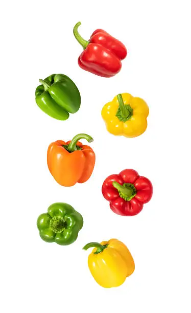 Photo of Falling peppers isolated on a white background. Flying colorful bell pepper pattern. Design for packaging. Vegetable fly.