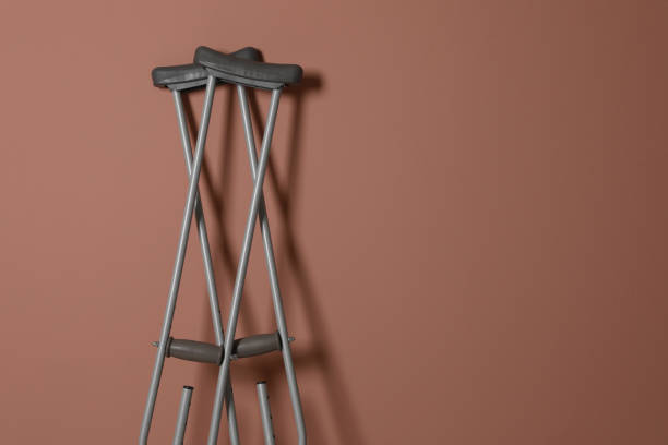 istock Pair of axillary crutches on pale pink background. Space for text 1331077188