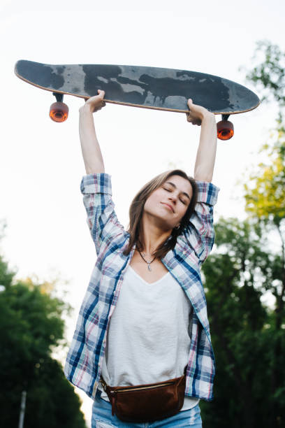 istock Tired happy woman stretching with a skateboard in hands. Low angle. 1331077298