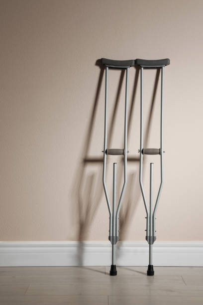 istock Pair of axillary crutches near beige wall. Space for text 1331078252