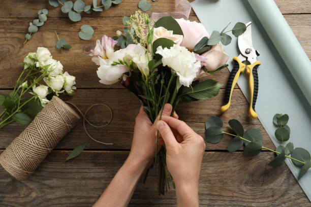 istock Florist creating beautiful bouquet at table, top view 1331078340