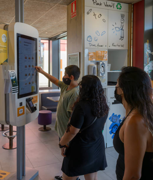 Mallorca, Spain, 07-27-2021:People at self service order machines from MacDonald's fast, technology concept Mallorca, Spain, 07-27-2021: People at self service order machines from MacDonald's fast, technology concept, spanish hamburger stock pictures, royalty-free photos & images