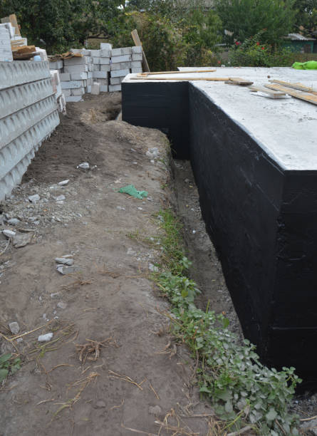 istock Waterproofing basement, house foundation applying tar. Spraying tar while waterproofing foundation. 1331080224