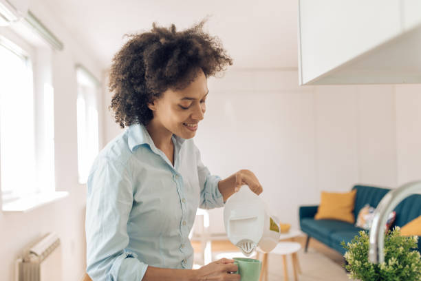 istock Happy woman preparing morning coffee before work 1331081636