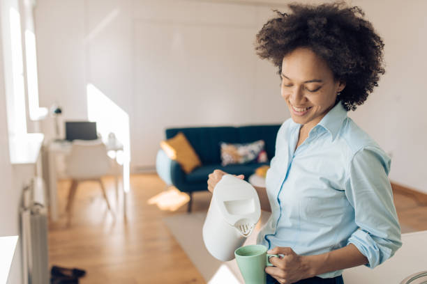 istock Happy woman preparing morning coffee before work 1331081641