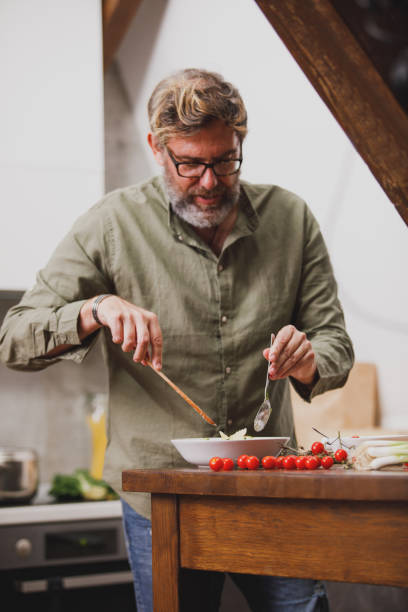 istock Man mixing up a dish in a bowl for dinner 1331081725
