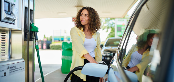 mujer llenando en la gasolinera photo