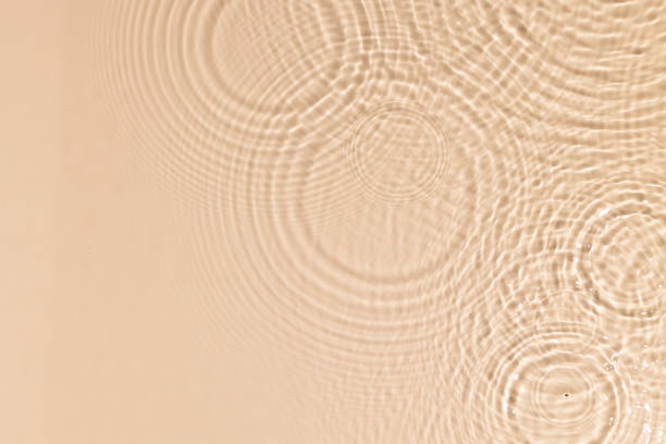 istock Beige water texture with ripples and transparent at sunlight. Backdrop for cosmetic or spa concept background. Copy space 1331083340