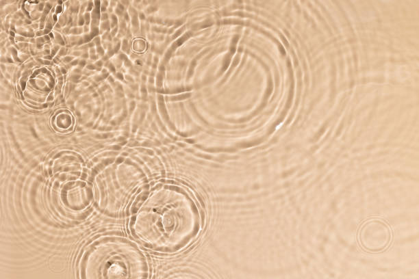 istock Beige water texture with ripples and transparent at sunlight. Backdrop for cosmetic or spa concept background. Copy space 1331083388