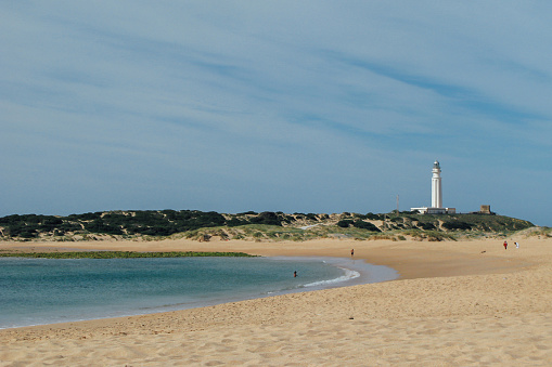 Landscape of a beach and a lighthouse in the distance in the autonomous community of Ansalusia, Spain. Concept of travel.