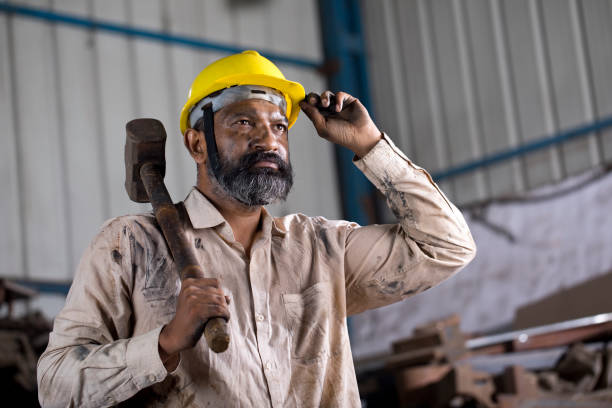 istock Industrial worker holding hammer while working at factory 1331084827