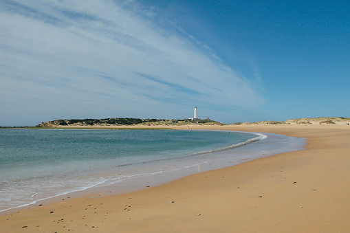 Landscape of a beach and a lighthouse in the distance in the autonomous community of Ansalusia, Spain. Concept of travel.