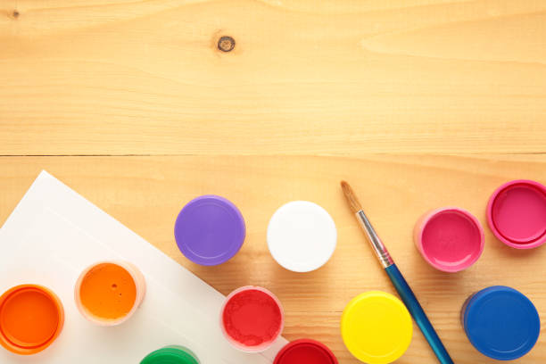 istock Multicolored jars of gouache and a brush on a light background. Creative kit. 1331087719