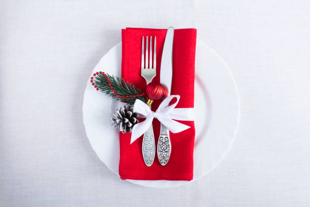 istock Christmas table setting with a red napkin on the white tablecloth. Top view. Copy space. 1331088091