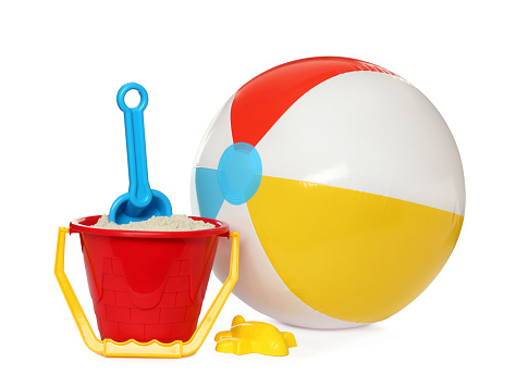 Inflatable colorful beach ball and child plastic toys on white background