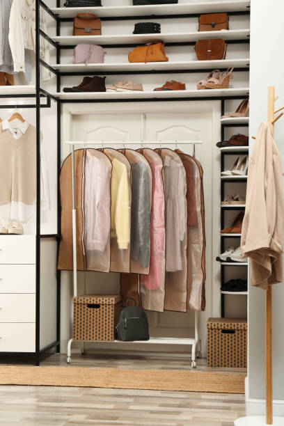istock Garment bags with clothes on rack in dressing room 1331088992