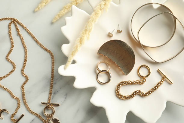 diferentes bijouterie elegante e placa em mesa de mármore branco, leigo plano - necklace gold bracelet jewelry - fotografias e filmes do acervo