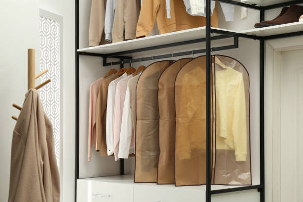 Garment bags with clothes on rack in dressing room Garment bags with clothes on rack in dressing room vogue cover stock pictures, royalty-free photos & images
