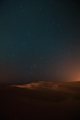 Orange dunes and starry sky. Night in the desert.