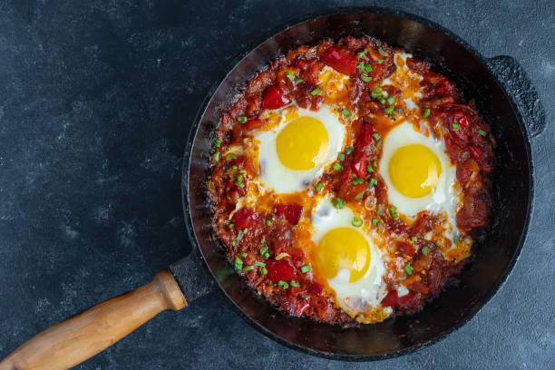 istock Shakshuka, fried eggs with tomatoes, onion, red pepper and spices in cast iron pan 1331093175